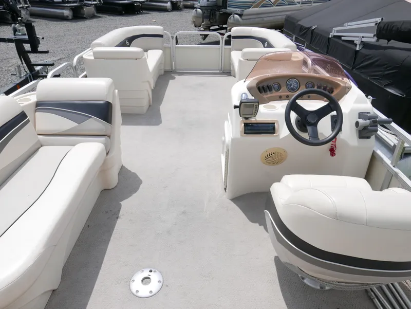 Slide: The Image of 2007 Sedona L23 pontoon boat interior with white seating and steering console. - 10