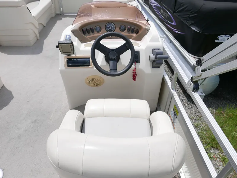 Slide: The Image of Captain's seat and helm of 2007 Sedona L23 boat, featuring steering wheel and control panel. - 7