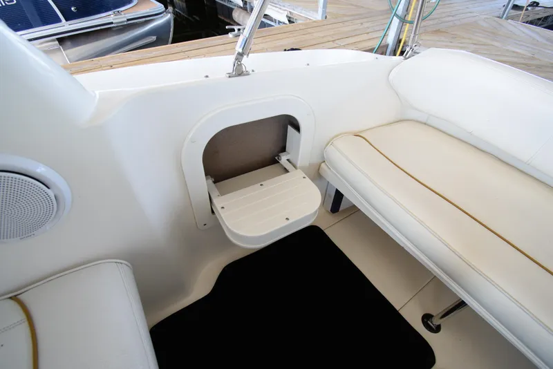 Slide: The Image of 1999 Sea Ray 290 Sundancer boat interior with white seating and storage compartment. - 10