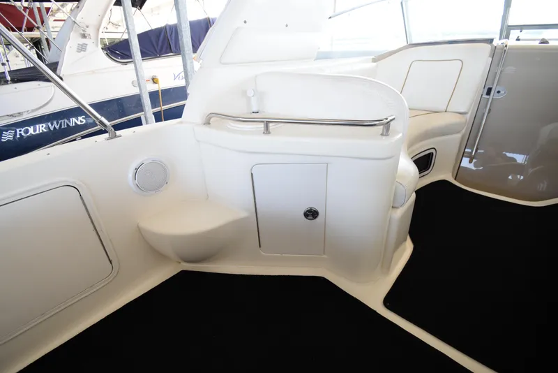 Slide: The Image of Interior of 1999 Sea Ray 290 Sundancer boat with white seating and storage compartments. - 11