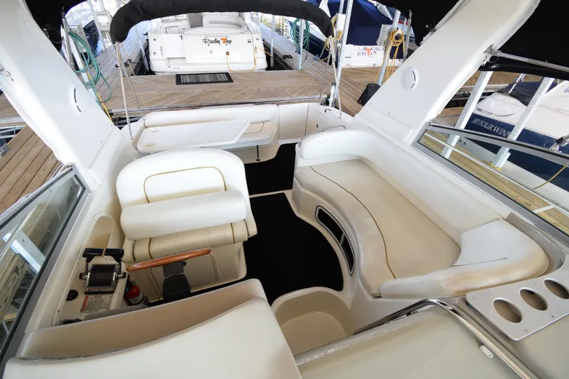 Slide: The Image of 1999 Sea Ray 290 Sundancer boat interior with white seating and control panel. - 12