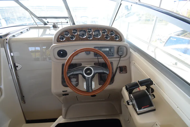 Slide: The Image of 1999 Sea Ray 290 Sundancer helm with wood steering wheel and control panel. - 17