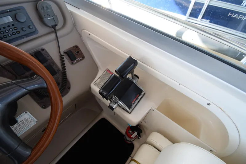 Slide: The Image of 1999 Sea Ray 290 Sundancer helm controls and steering wheel. - 18