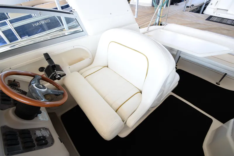 Slide: The Image of 1999 Sea Ray 290 Sundancer helm with white captain's chair and wooden steering wheel. - 20