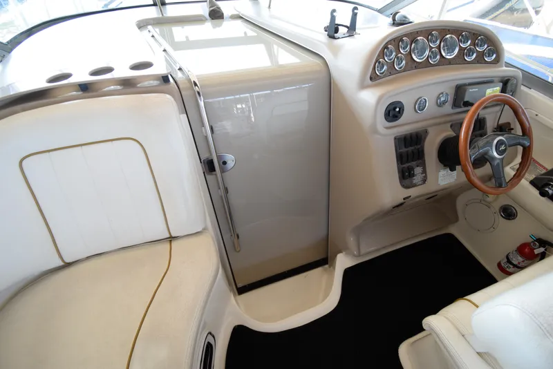 Slide: The Image of 1999 Sea Ray 290 Sundancer cockpit with steering wheel and control panel. - 21