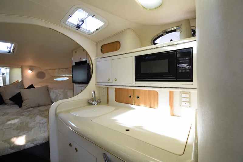 Slide: The Image of Interior of 1999 Sea Ray 290 Sundancer with kitchenette and sleeping area. - 23