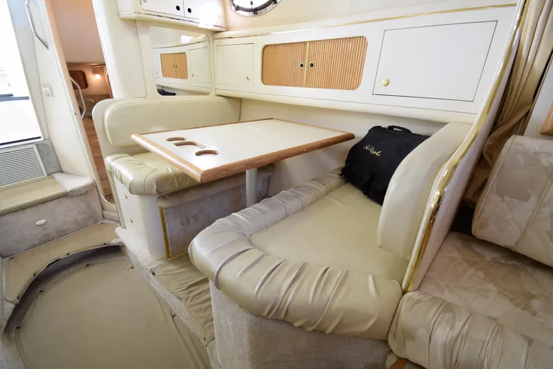 Slide: The Image of 1999 Sea Ray 290 Sundancer cabin interior with dining area and seating. - 29