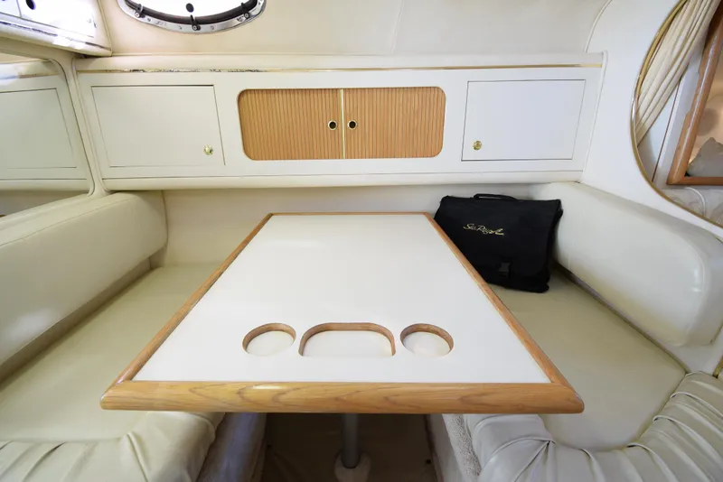 Slide: The Image of Interior dining area of a 1999 Sea Ray 290 Sundancer boat with table and seating. - 31