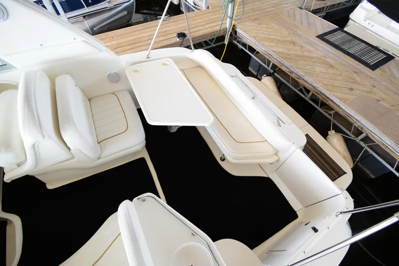 Slide: The Image of 1999 Sea Ray 290 Sundancer boat interior with white seating and table. - 5
