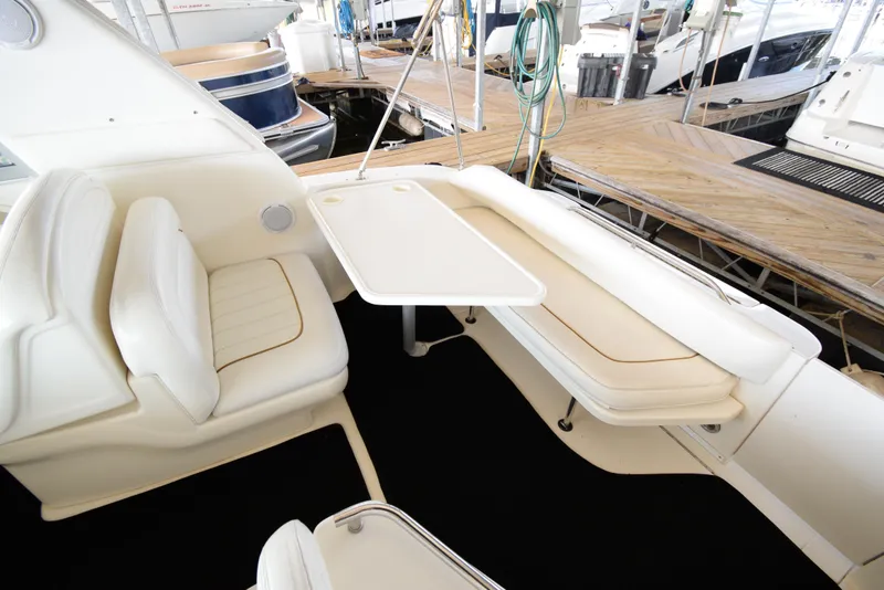 Slide: The Image of 1999 Sea Ray 290 Sundancer boat interior with seating and table at dock. - 7