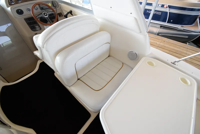 Slide: The Image of 1999 Sea Ray 290 Sundancer cockpit with white seating and table. - 9