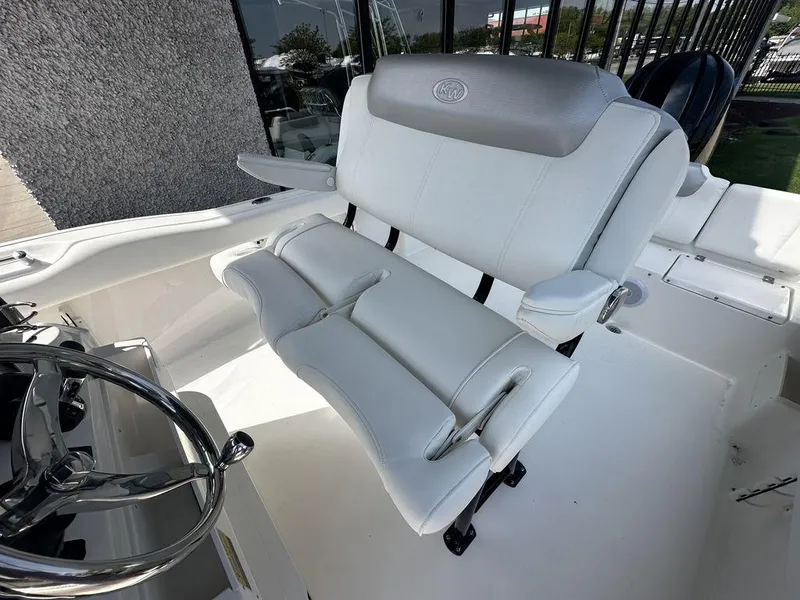 Slide: The Image of 2024 Key West 239 FS boat interior with white cushioned seating and steering wheel. - 4