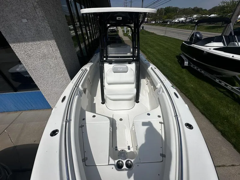 Slide: The Image of 2024 Key West 239 FS boat with white interior, docked near a building. - 6