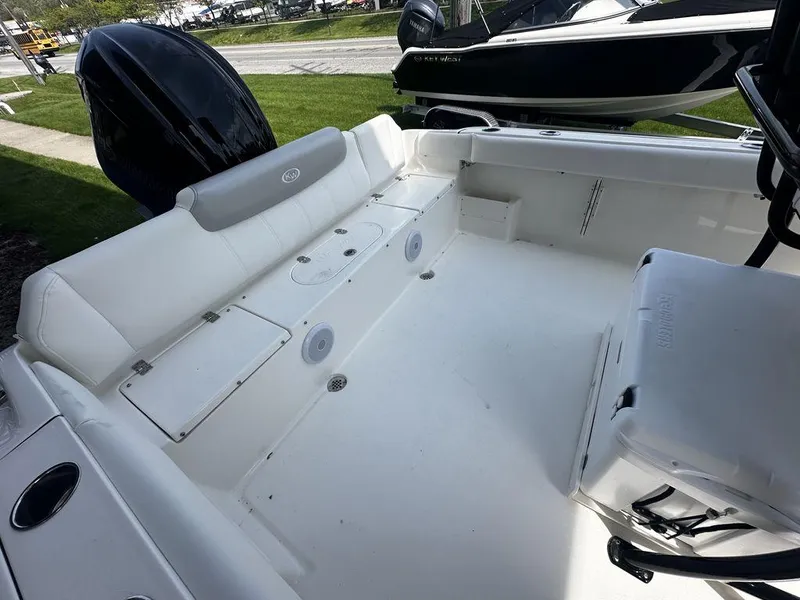 Slide: The Image of 2024 Key West 239 FS boat interior with white seating and storage compartments. - 7
