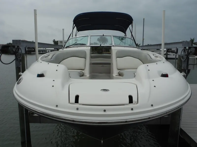 Slide: The Image of 2007 Sea Ray 240 Sundeck boat docked, front view with seating and canopy. - 2