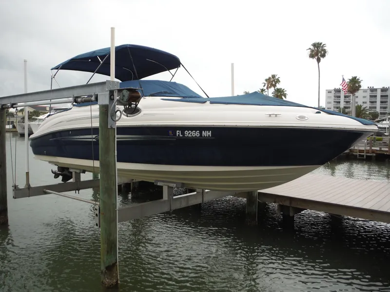 Slide: The Image of 2007 Sea Ray 240 Sundeck boat docked on a lift in a marina. - 37
