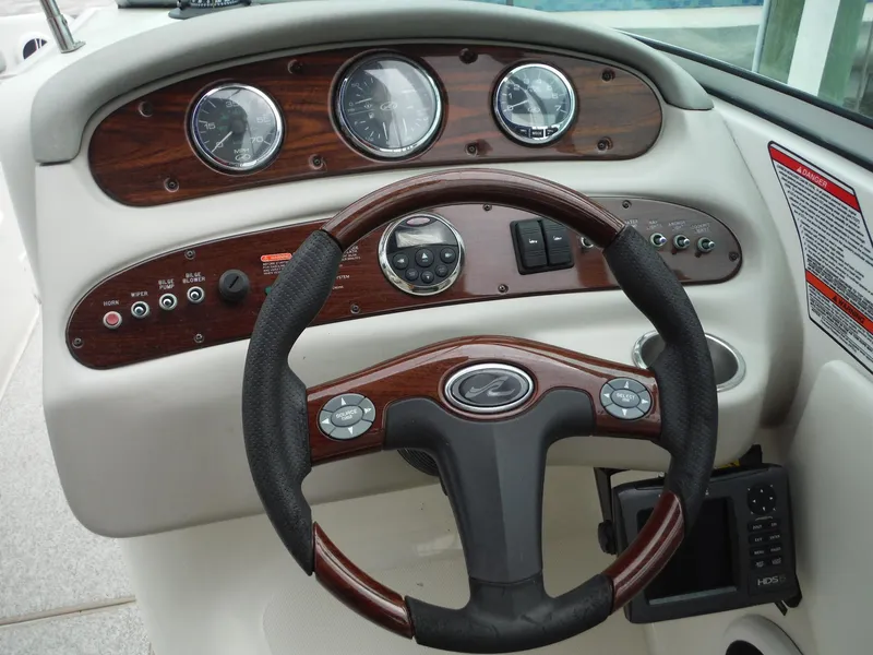 Slide: The Image of 2007 Sea Ray 240 Sundeck dashboard with steering wheel and control panel. - 12
