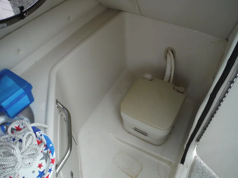 Slide: The Image of 2007 Sea Ray 240 Sundeck interior with portable toilet and storage area. - 10