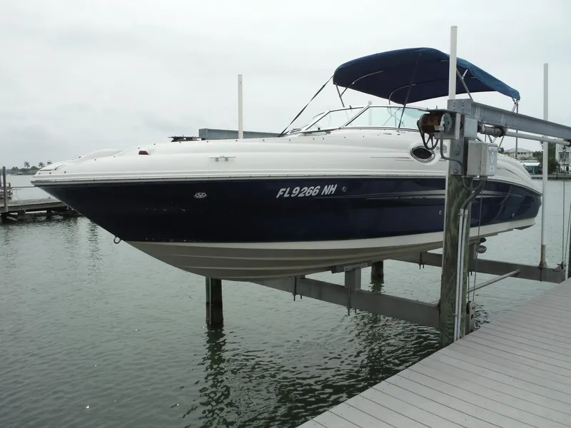 Slide: The Image of 2007 Sea Ray 240 Sundeck boat docked on a lift at a marina. - 0