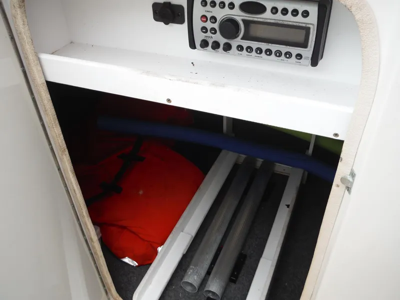 Slide: The Image of Storage compartment of a 2007 Sea Ray 240 Sundeck with radio, life jacket, and equipment. - 27