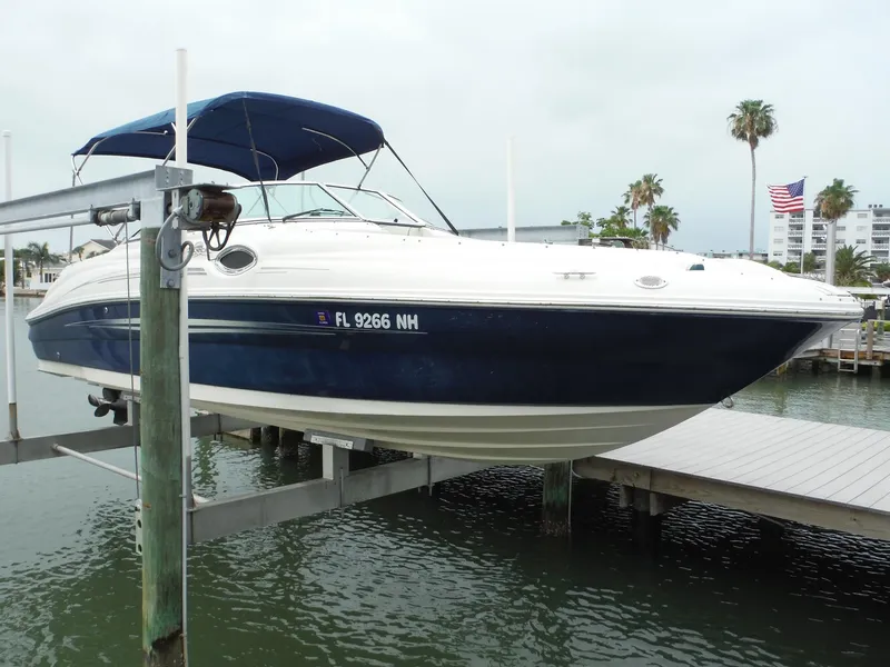 The Image of 2007 Sea Ray 240 Sundeck boat docked with blue hull and canopy. - 1