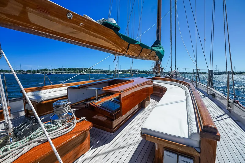 Slide: The Image of 1929 Lyman-Morse Staysail Schooner deck with polished wood and white seating. - 12