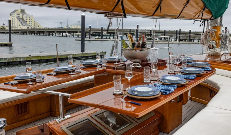 Slide: The Image of Elegant dining setup on 1929 Lyman-Morse Staysail Schooner, docked at marina. - 17