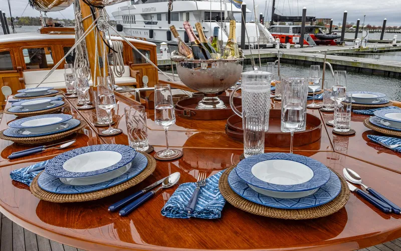 Slide: The Image of Elegant dining setup on 1929 Lyman-Morse Staysail Schooner, featuring blue and white tableware. - 18