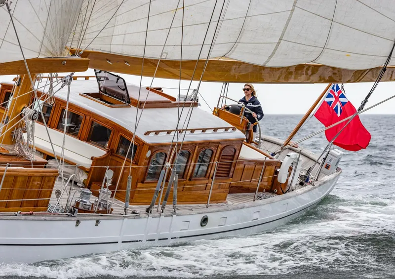 Slide: The Image of 1929 Lyman-Morse Staysail Schooner sailing with red ensign flag on open sea. - 3