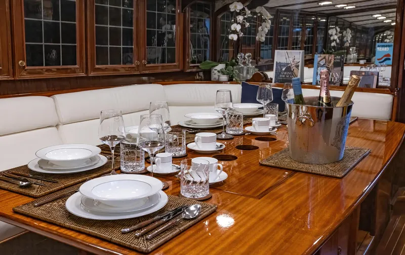 Slide: The Image of Elegant dining setup on 1929 Lyman-Morse Staysail Schooner with polished wood table and fine china. - 30