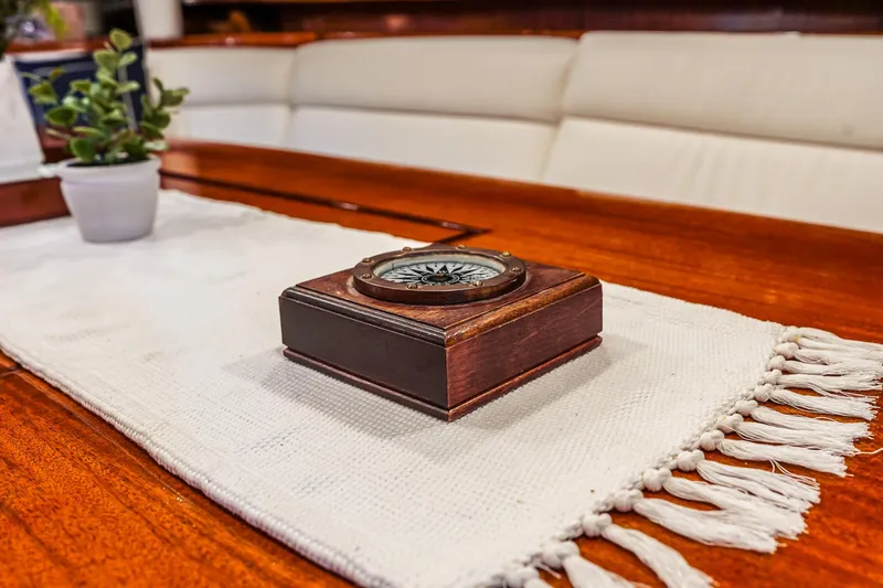 Slide: The Image of Wooden compass on a Lyman-Morse 1929 Staysail Schooner's elegant table setting. - 32
