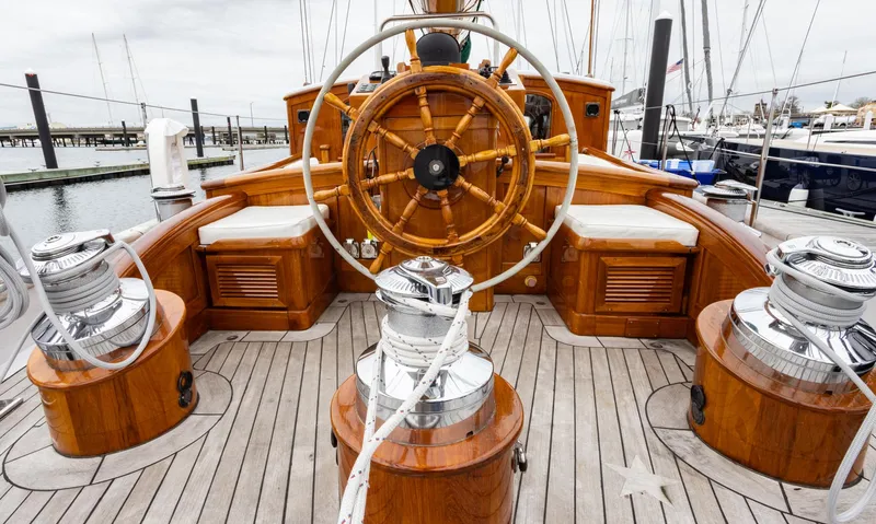Slide: The Image of 1929 Lyman-Morse Staysail Schooner's wooden helm and deck with chrome winches. - 4