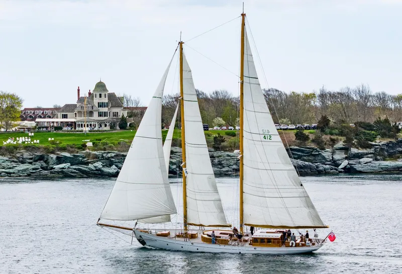 Slide: The Image of 1929 Lyman-Morse Staysail Schooner sailing near a coastal mansion. - 57