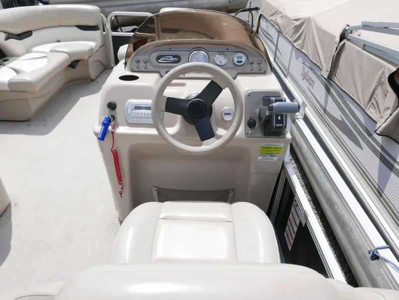 Slide: The Image of 2012 Sylvan Mirage 820 boat cockpit with steering wheel and control panel. - 7