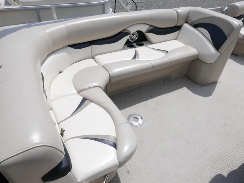 Slide: The Image of 2012 Sylvan Mirage 820 boat interior with beige and black cushioned seating. - 8