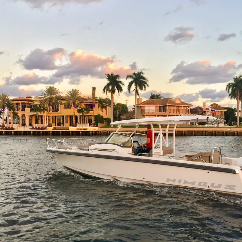 The Image of 2024 Nimbus Tender 9 boat cruising near luxury waterfront homes at sunset. - 1