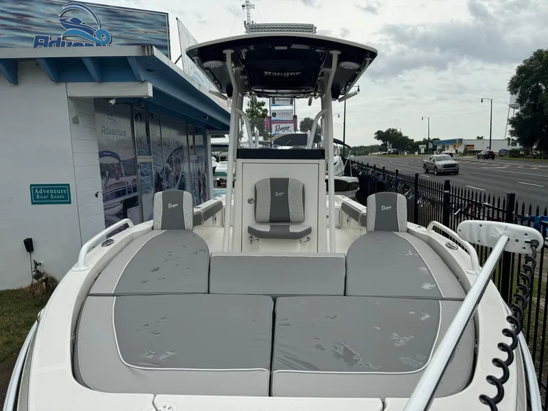 Slide: The Image of 2024 Ranger 2510 boat with gray seating, displayed at a dealership. - 6