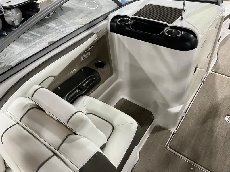 Slide: The Image of 2013 Yamaha Boats 242 Limited S interior seating and console area with cup holders. - 9