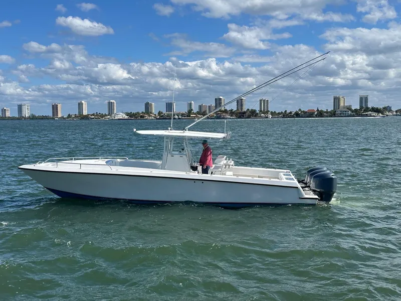 Slide: The Image of 2006 Contender 36 Cuddy boat on water with city skyline in background. - 0