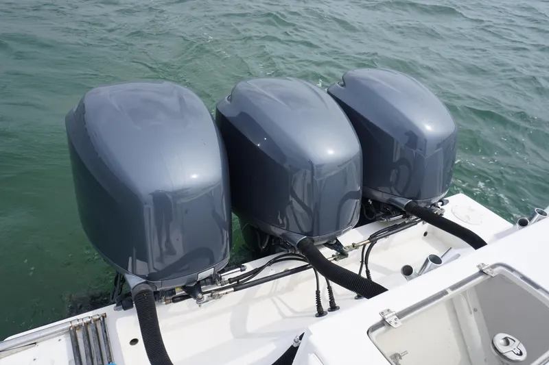 Slide: The Image of Triple outboard motors on a 2006 Contender 36 Cuddy boat in the water. - 10