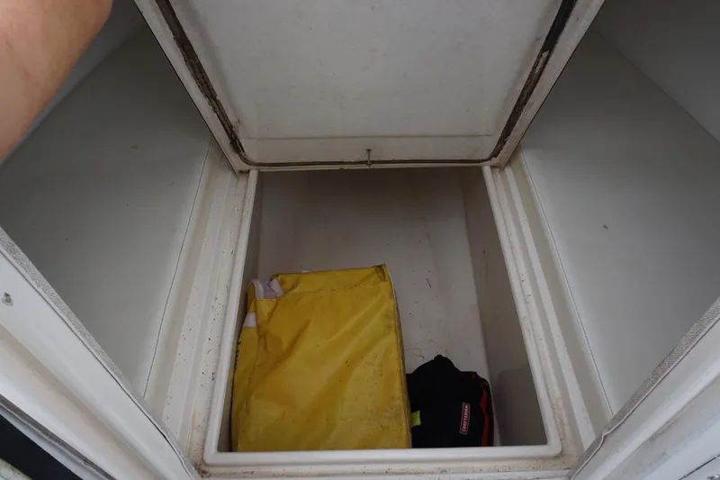 Slide: The Image of Storage compartment of a 2006 Contender 36 Cuddy boat with yellow and black bags. - 20