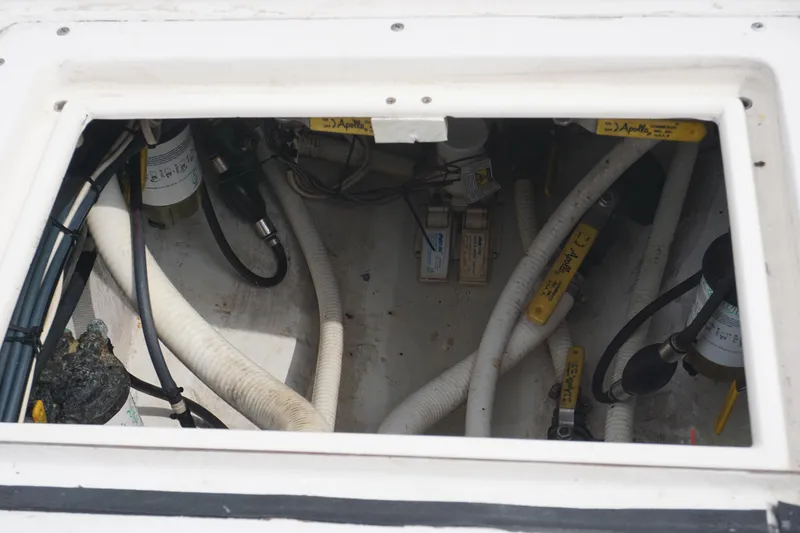 Slide: The Image of Engine compartment of a 2006 Contender 36 Cuddy boat with visible hoses and components. - 29