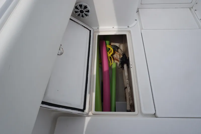 Slide: The Image of Storage compartment on a 2006 Contender 36 Cuddy boat with pool noodles and gear. - 30