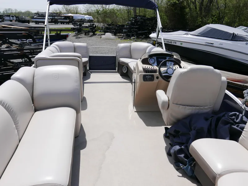 Slide: The Image of 2017 Sweetwater SWPE 255 SB pontoon boat with beige seating and steering console. - 9
