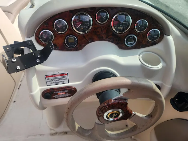 Slide: The Image of 2003 Sea Ray 220 Sundeck dashboard with steering wheel and instrument panel. - 10