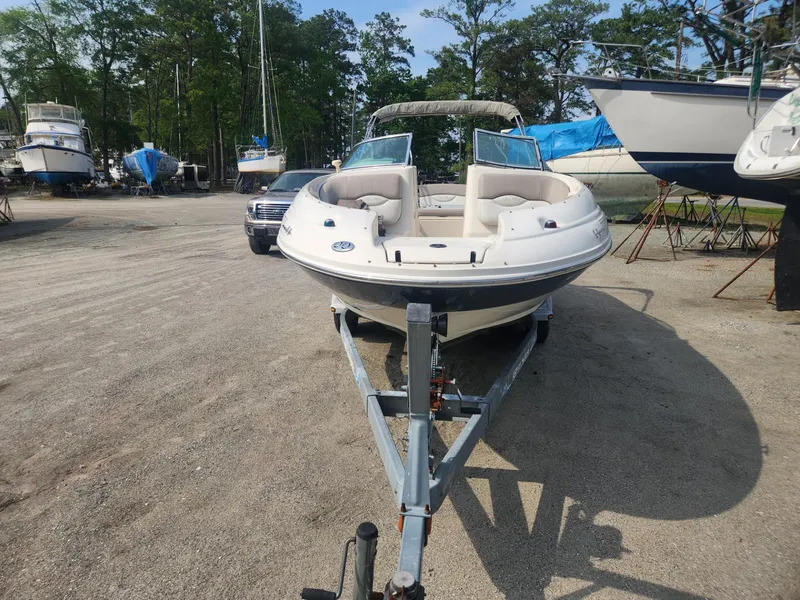 Slide: The Image of 2003 Sea Ray 220 Sundeck boat on a trailer in a marina. - 6