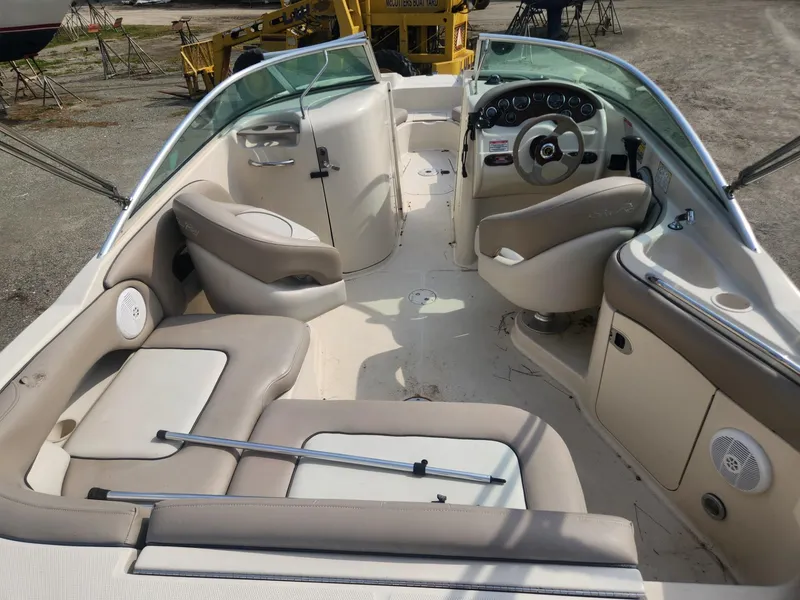 Slide: The Image of 2003 Sea Ray 220 Sundeck boat interior with beige seating and steering console. - 7