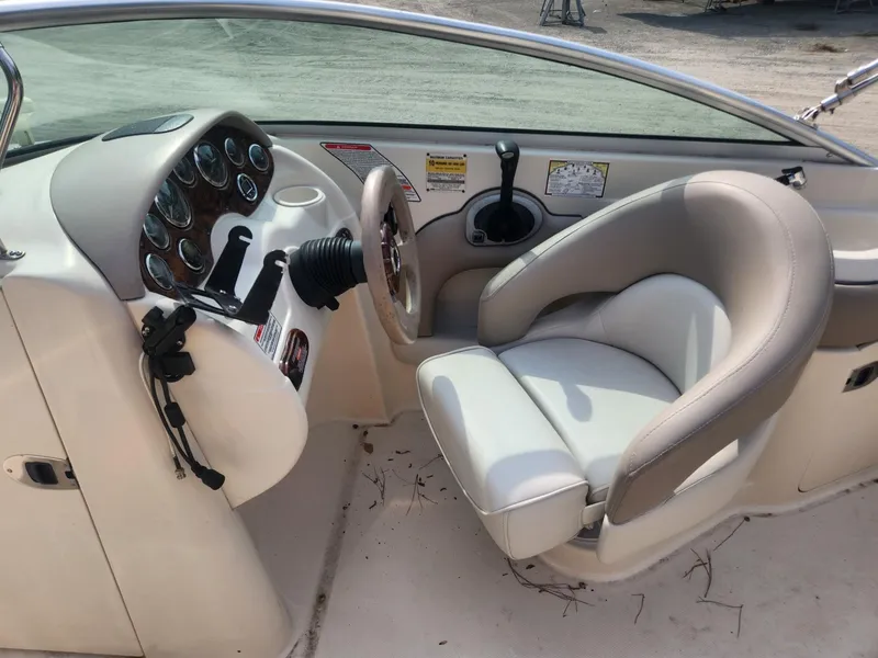 Slide: The Image of 2003 Sea Ray 220 Sundeck boat cockpit with steering wheel and captain's chair. - 9