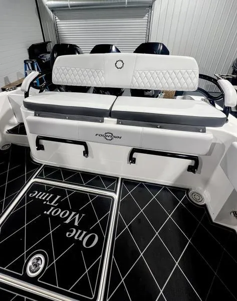 Slide: The Image of 2022 Fountain 34 TE boat interior with cushioned seating and black diamond-patterned flooring. - 12