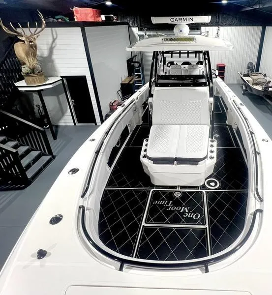 Slide: The Image of 2022 Fountain 34 TE boat with Garmin electronics, black and white interior, and mounted deer head. - 2